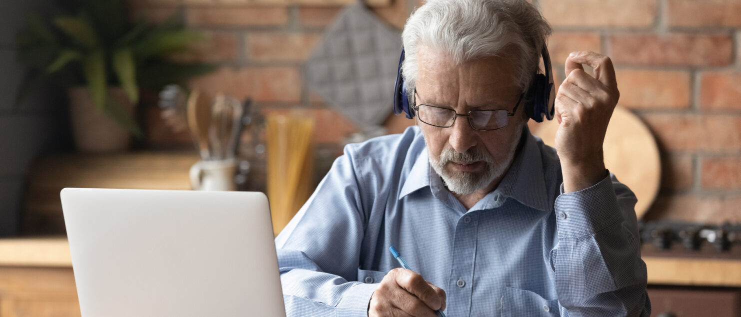 An older man working on a laptop.