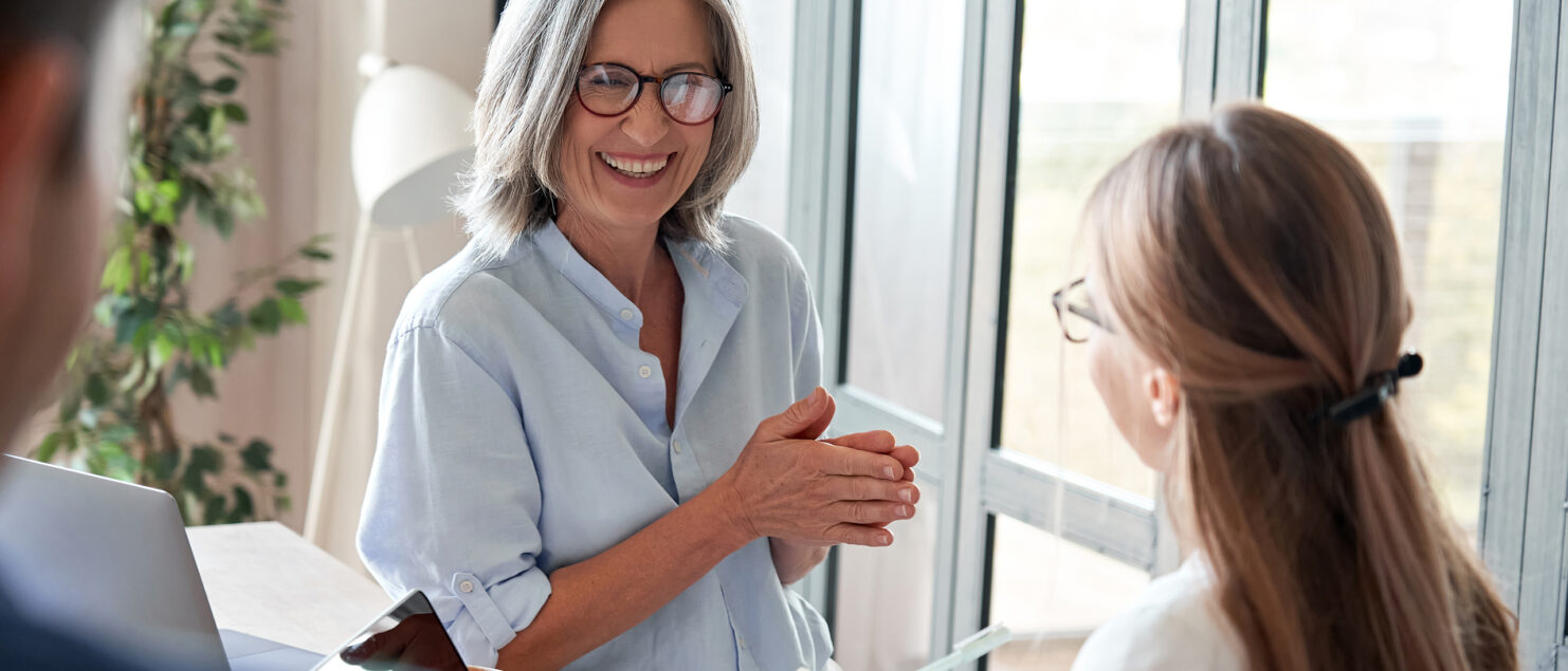 A mature businesswoman coaches a younger colleague