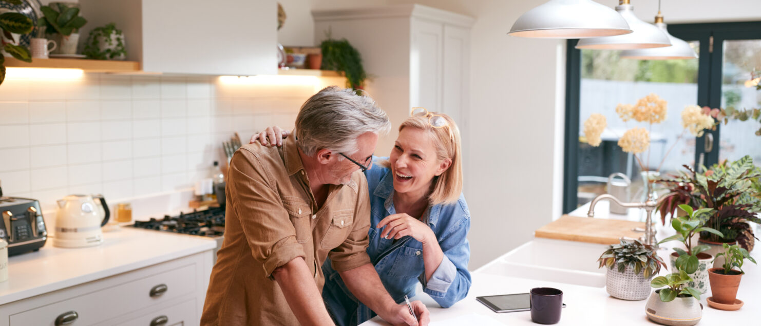 A couple filling in paperwork in their kitchen