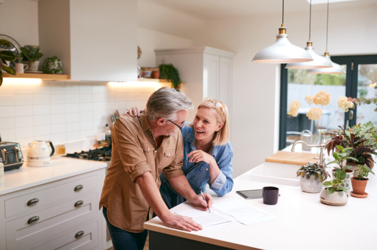 A couple filling in paperwork in their kitchen